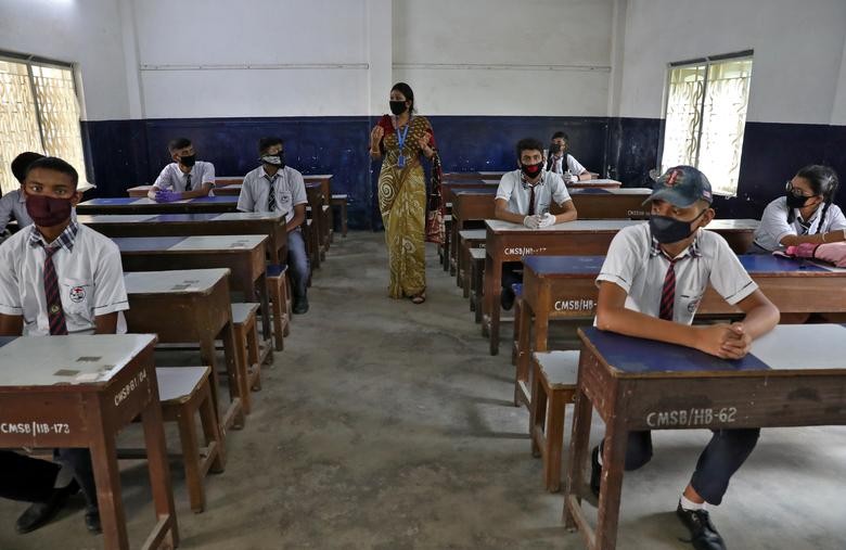 Students wearing protective masks listen to their teacher as they maintain social distancing in a classroom of Central Model School during a demonstration session for the students, parents and teaching staff before the reopening of the school, as India eases lockdown restrictions that were imposed to slow the spread of the coronavirus disease (COVID-19), at Barrackpore on the outskirts of Kolkata, India. REUTERS/Rupak De Chowdhuri